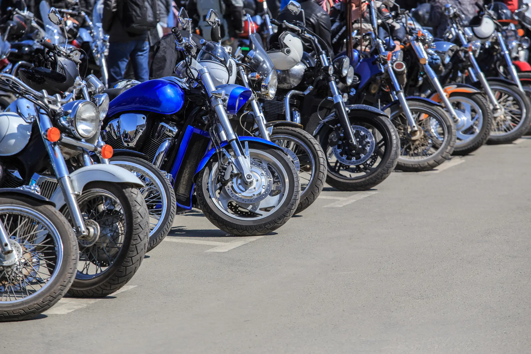 Lineup of parked motorcycles with shiny chrome details on a sunny day.